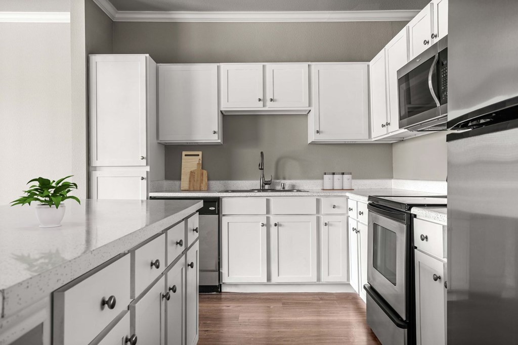 A kitchen with white cabinets and appliances.