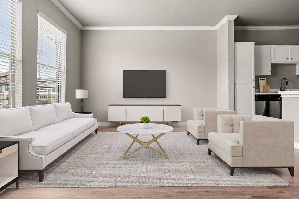 A modern living room with a white sofa, a coffee table, and a television.