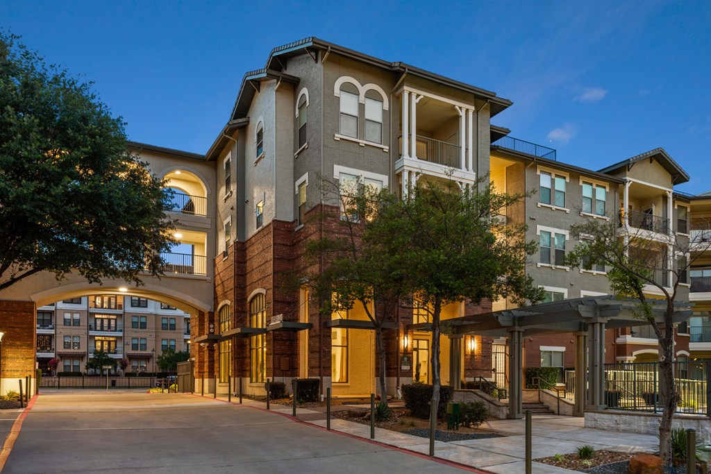 A large apartment complex with a courtyard and trees.