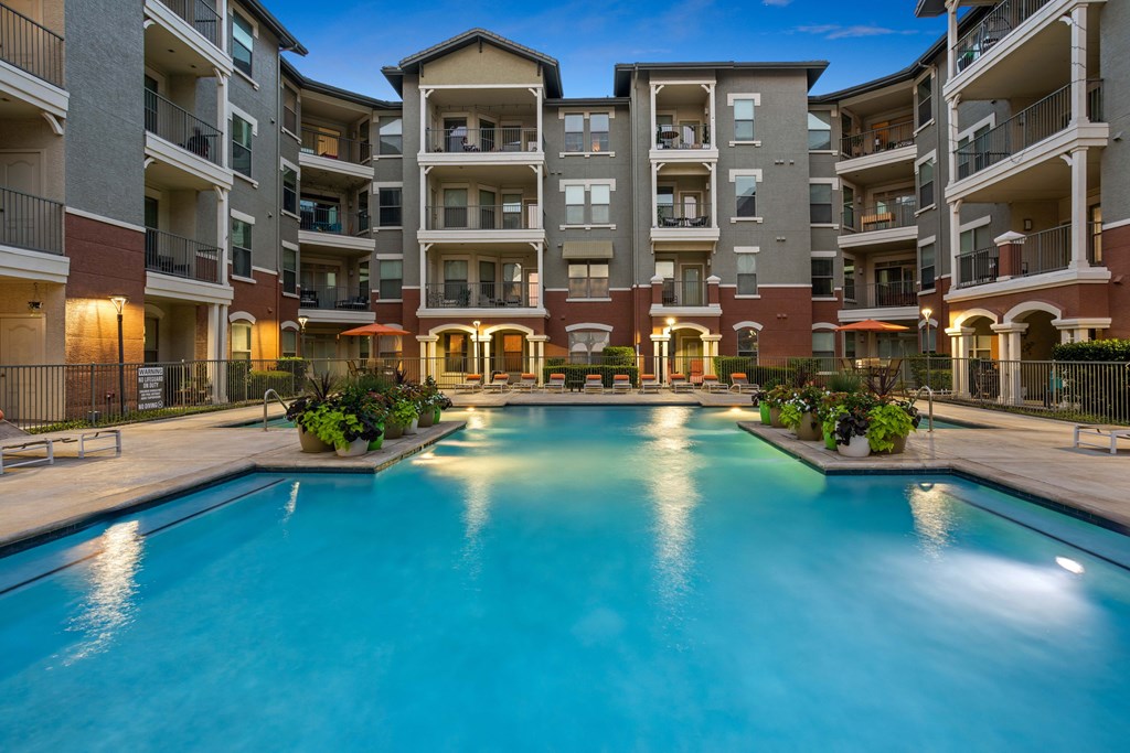 A large swimming pool in front of apartment buildings.