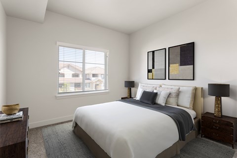 A bedroom with a large bed and a window overlooking a residential area.