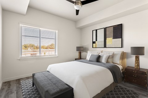 A bedroom with a large bed and a ceiling fan.
