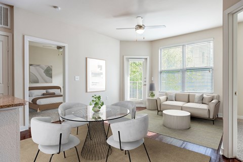 A modern dining room with a glass table and white chairs.