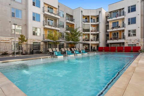 A swimming pool in front of a residential building.