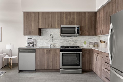 A modern kitchen with wooden cabinets and stainless steel appliances.