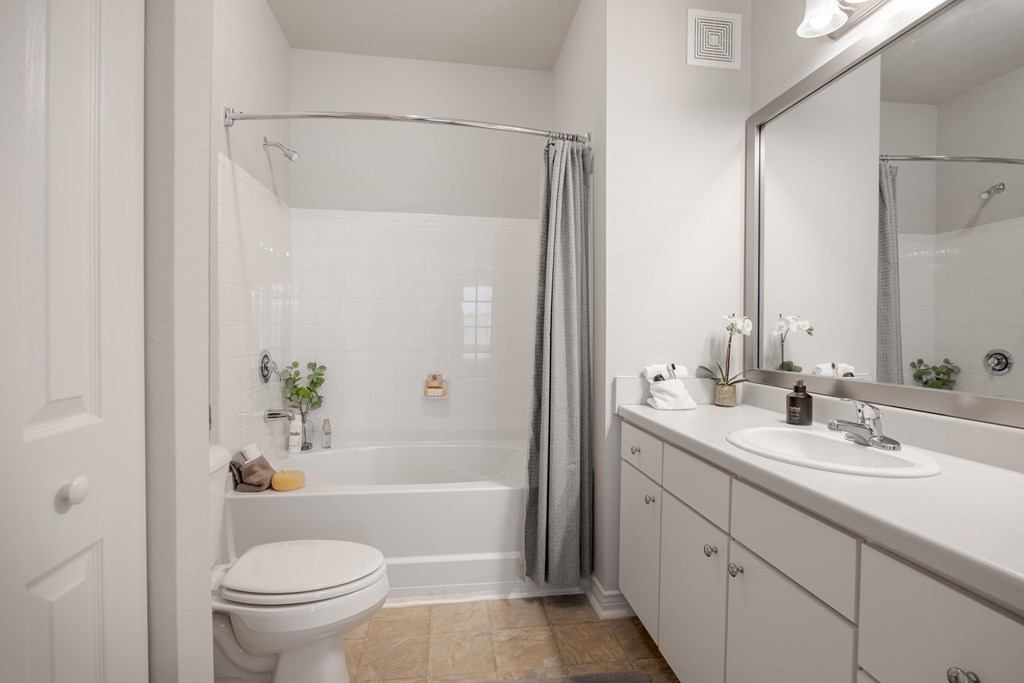 A white bathroom with a toilet, sink, and bathtub.