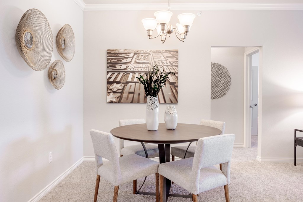 A dining room with a round table and chairs.