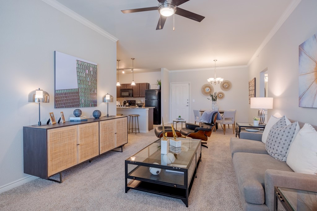 A living room with a grey couch, a coffee table, and a ceiling fan.