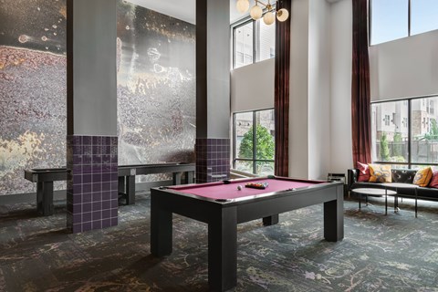 A pool table in a room with a view of the city.