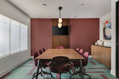A conference room with a long table and chairs.