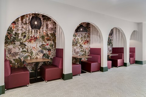 A room with arched windows and floral wallpaper.