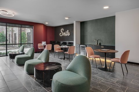 A modern lounge area with green chairs and a sign that says "Smile".