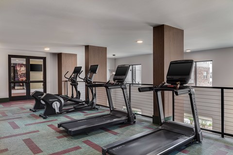 A gym with treadmills and elliptical machines.