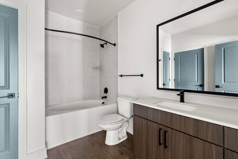 A white toilet sits next to a bathtub in a bathroom.
