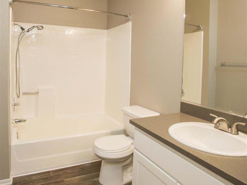 A white toilet sits next to a bathtub in a bathroom.