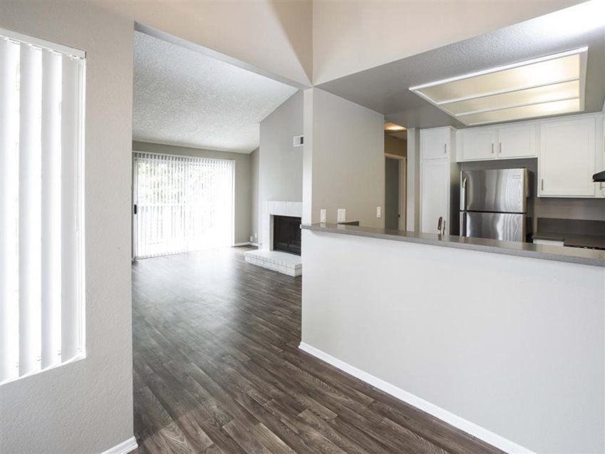 A kitchen with a refrigerator, stove, and cabinets.