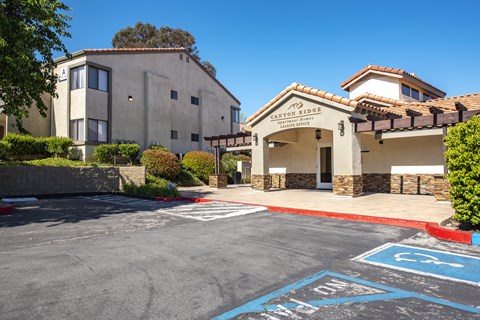 A parking lot with a building named Canyon Sides in the background.