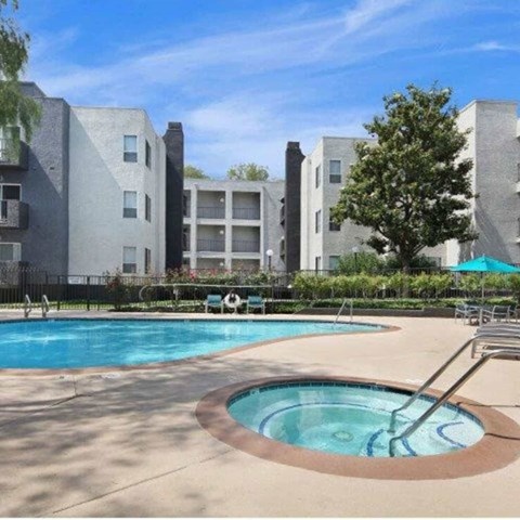 A swimming pool in front of apartment buildings.