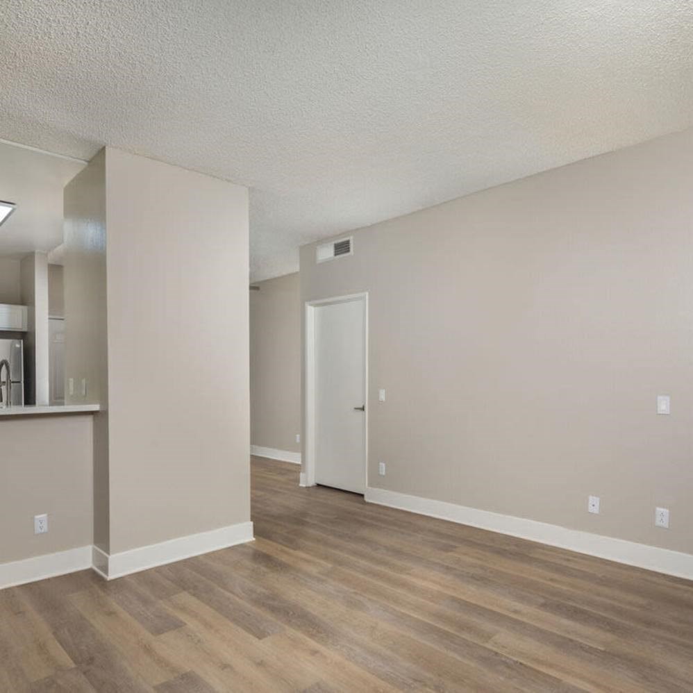 A room with a white door and a wooden floor.
