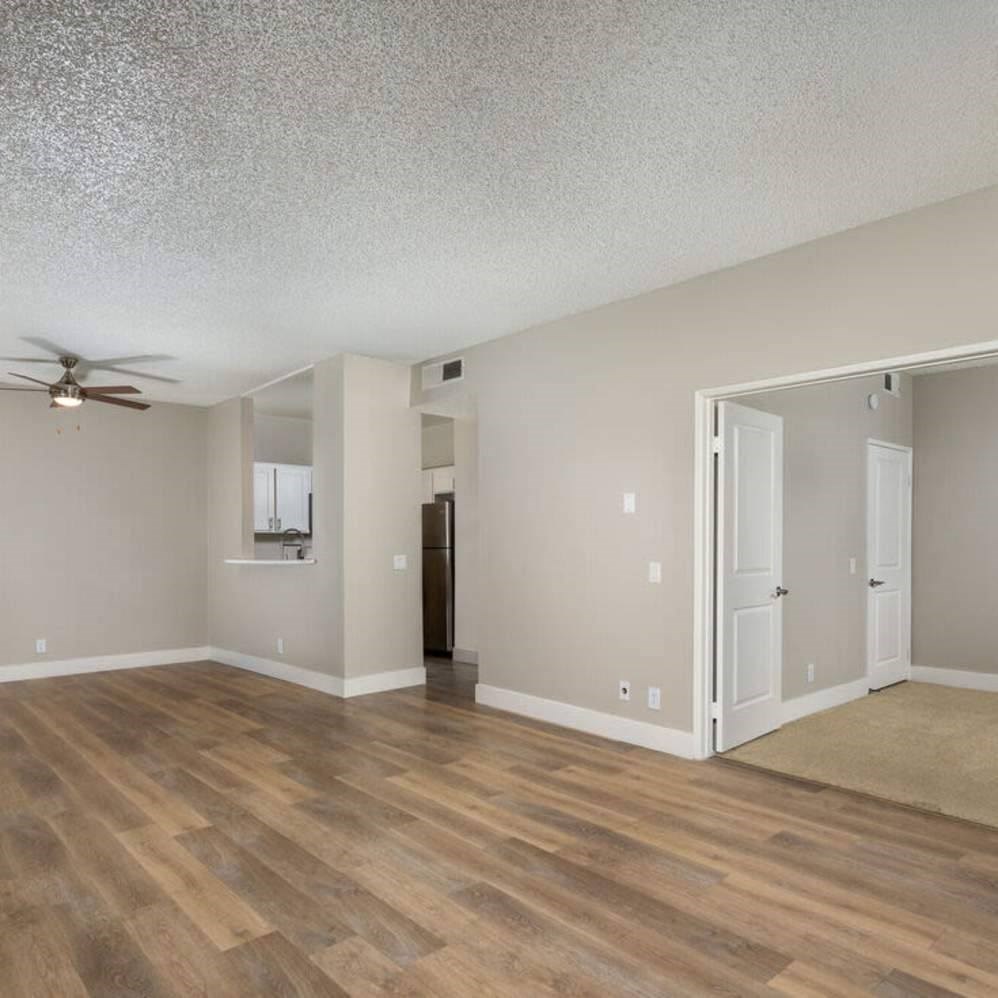 A room with a ceiling fan and wooden flooring.