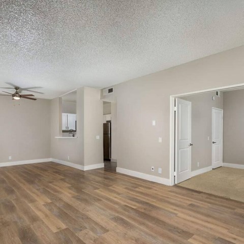 A room with a ceiling fan and wooden flooring.