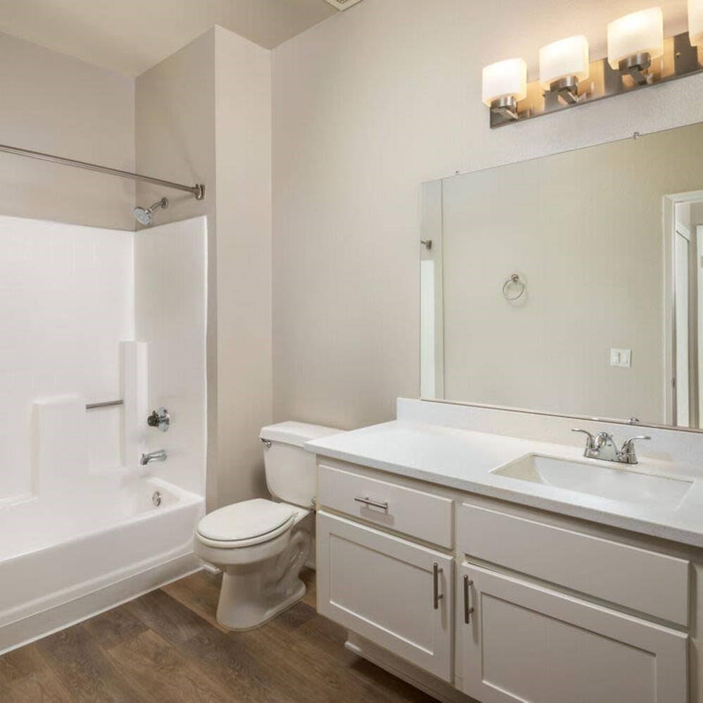 A white bathroom with a toilet, sink, and bathtub.