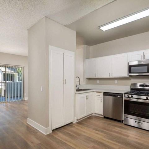 A kitchen with white cabinets and stainless steel appliances.