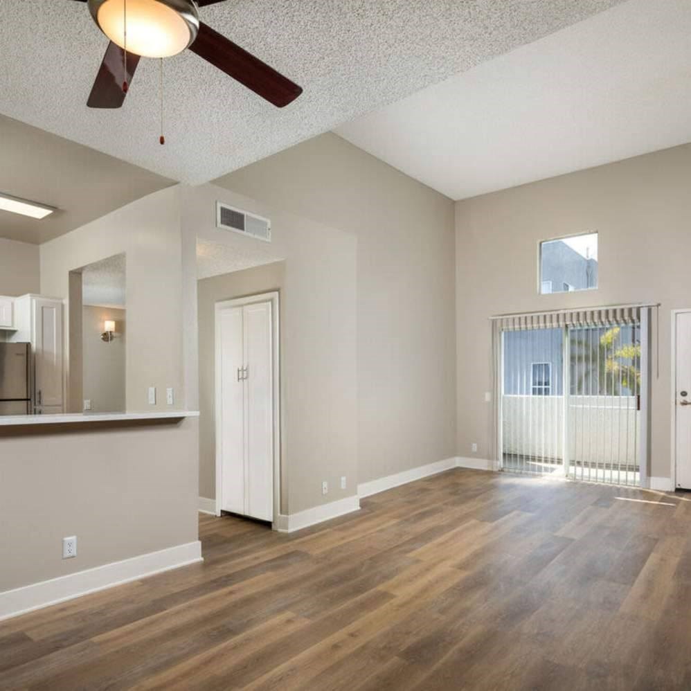 A room with a ceiling fan and wooden flooring.