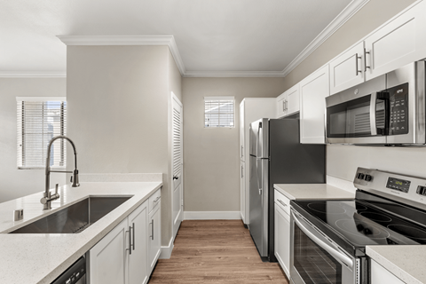 A kitchen with white cabinets and stainless steel appliances.