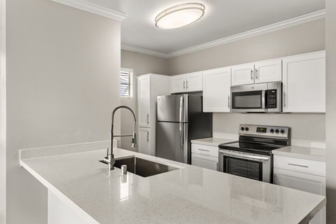 A kitchen with white cabinets and stainless steel appliances.