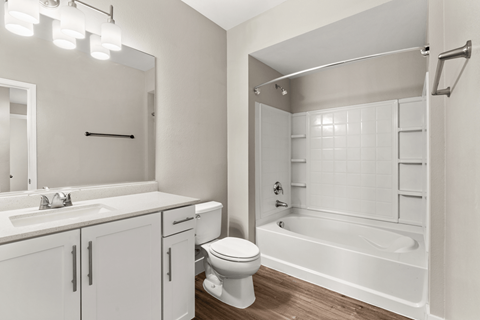 A white bathroom with a toilet, sink, and bathtub.