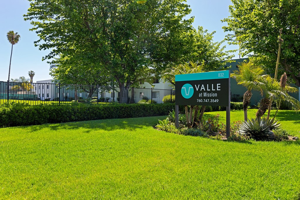A green sign with the word "Valle" on it is in front of a building.