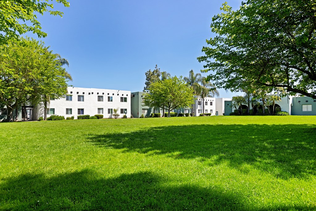 A white building with a green lawn in front of it.