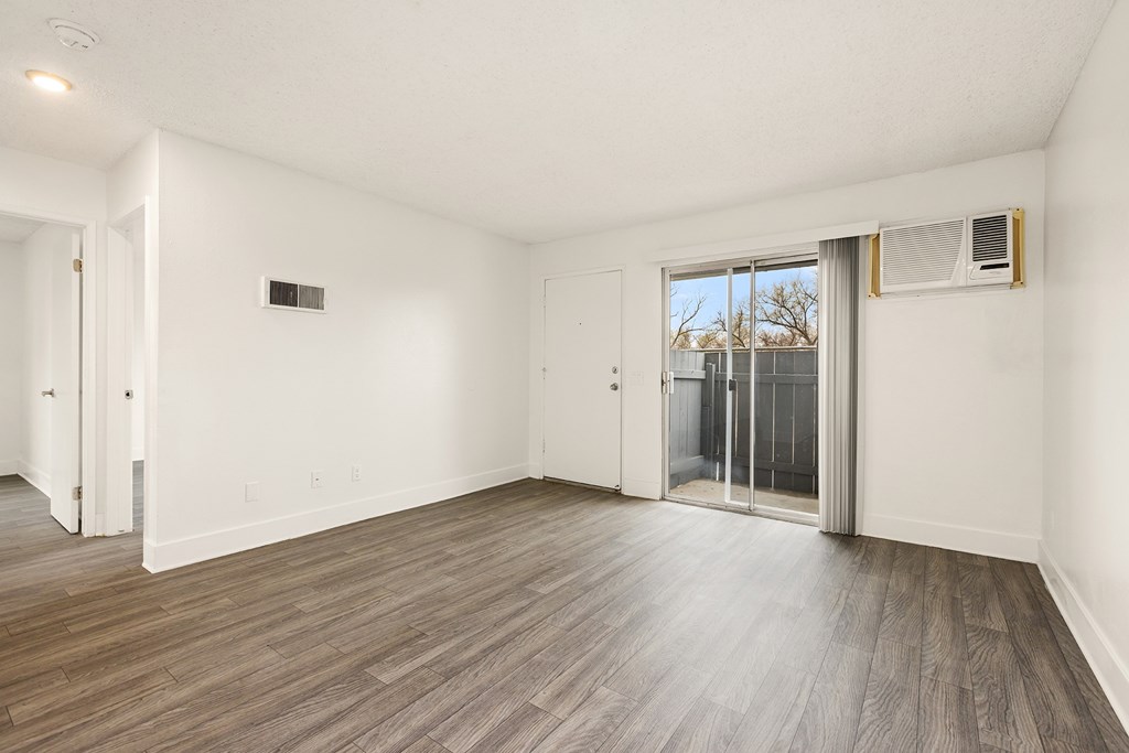 A room with a sliding glass door leading to a balcony.
