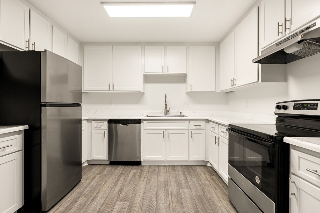 A modern kitchen with black appliances and white cabinets.