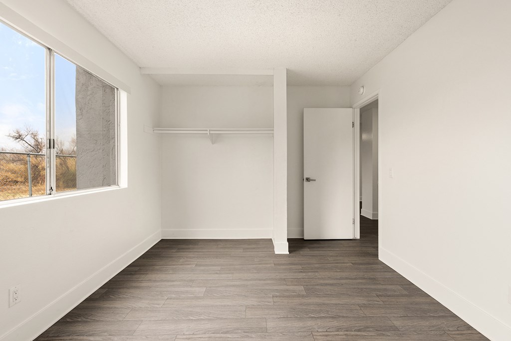 Empty room with white walls and wood flooring.