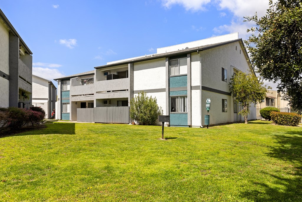 A building with a green lawn in front.