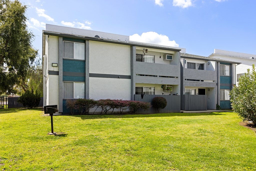 A grassy area in front of a building with a mailbox.