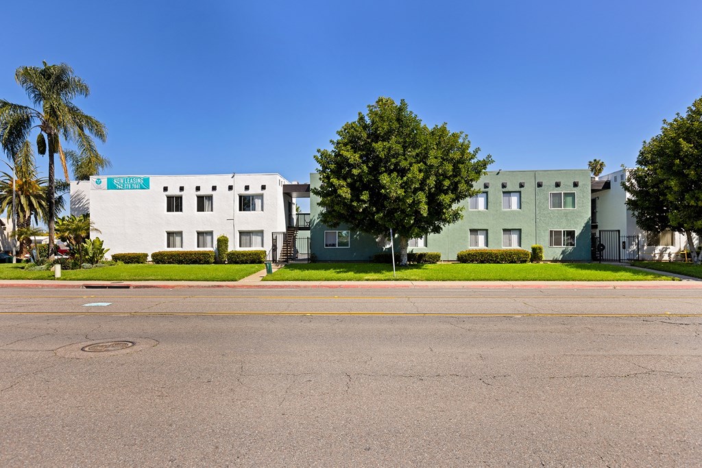 A street view with two buildings and a tree.
