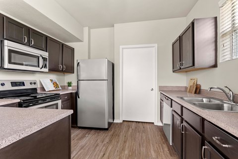 A kitchen with brown cabinets and a white door.