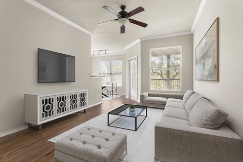 A living room with a grey couch, a glass coffee table, and a television on a cabinet.