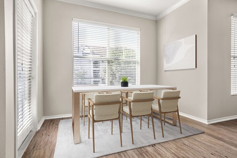 A dining room with a table and chairs.