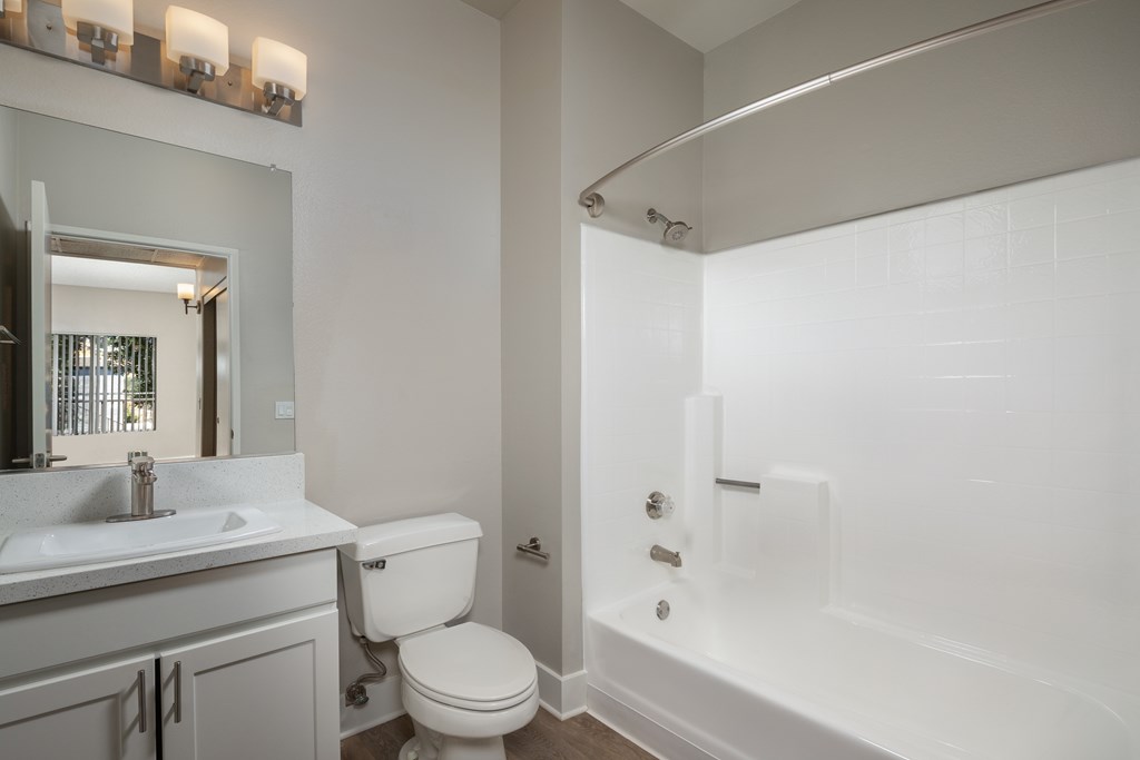 A white bathroom with a toilet, sink, and bathtub.