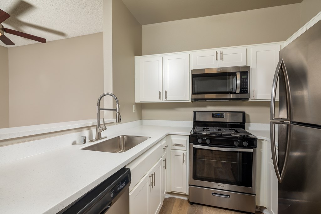 A modern kitchen with stainless steel appliances and white cabinets.