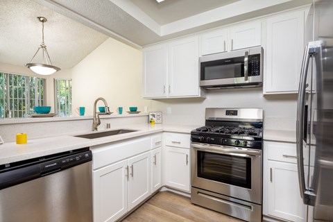 A kitchen with white cabinets and stainless steel appliances.