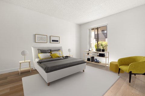 A bedroom with a white bed and yellow chair.