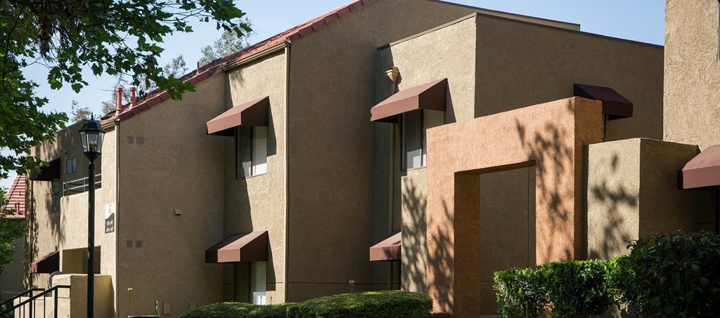 A building with beige walls and red awnings.