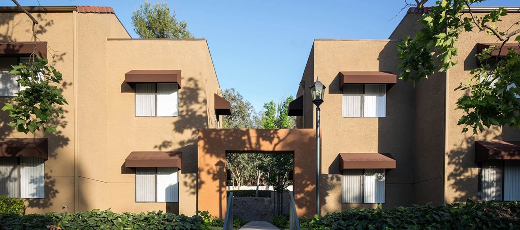 A building with brown and beige walls and white windows.