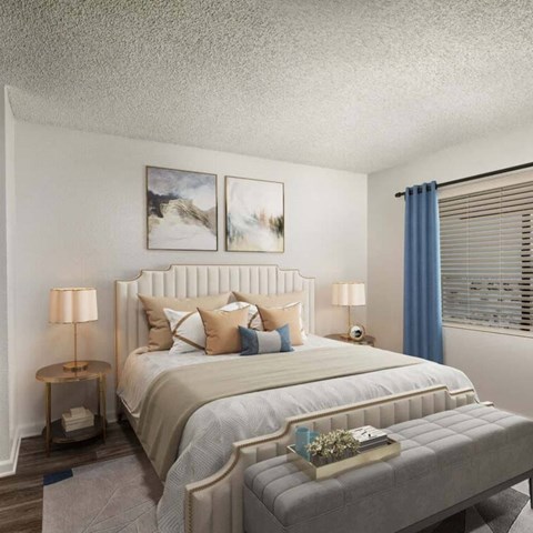 A bedroom with a large bed and two lamps.