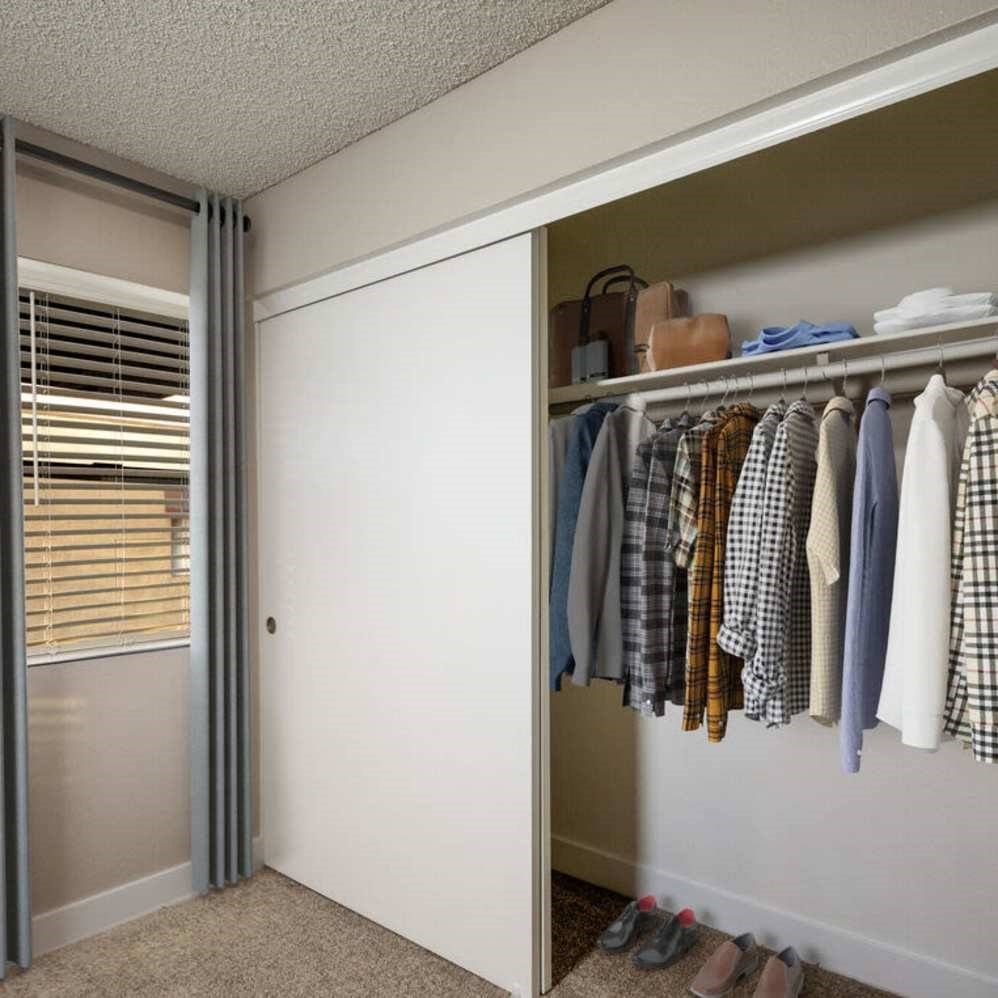 A closet with clothes and shoes.